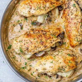 top view of 4 stuffed chicken breast in a gray skillet