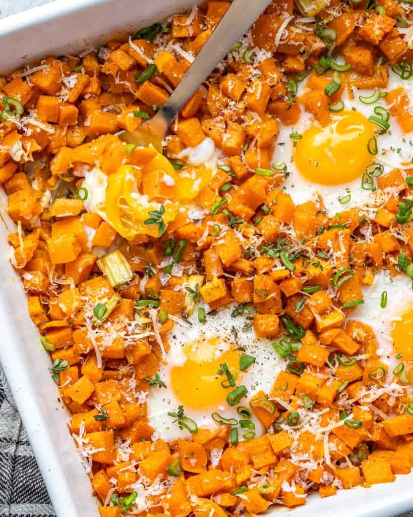 close up of sweet potato hash browns and eggs in a white dish