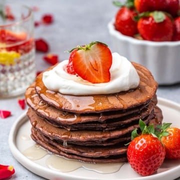 side shot red velvet pancakes with red roses in backgroundh