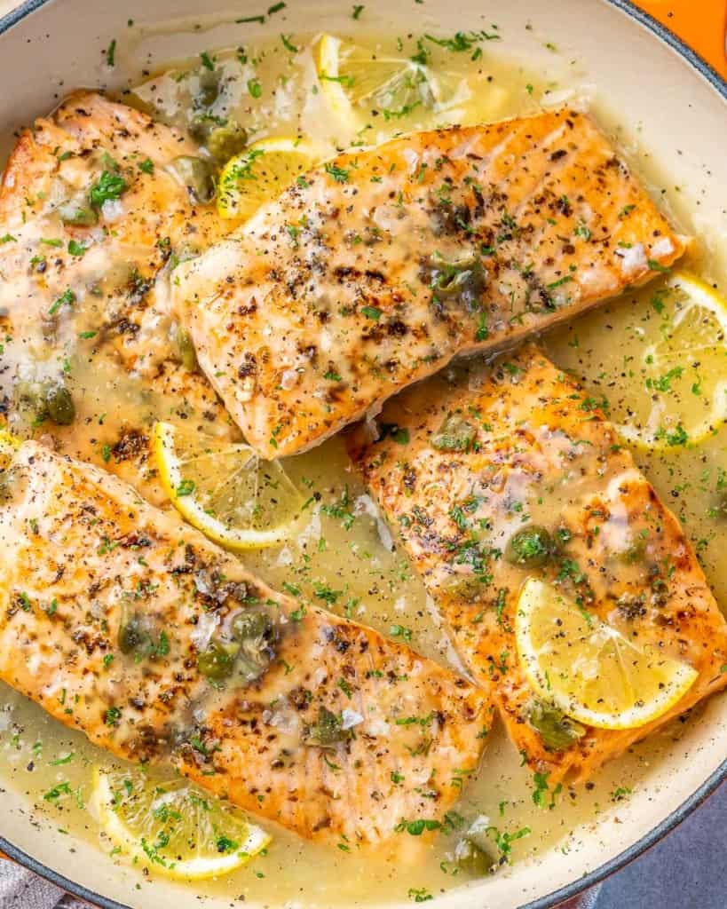 close up seared salmon in lemony piccata sauce