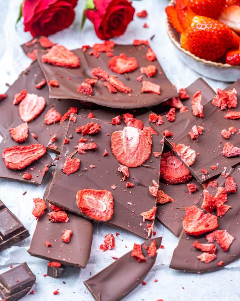 side shot of broke chocolate bark topped with strawberries 