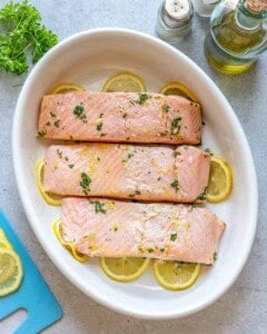 Marinate 3 salmon fillets in an oval dish.