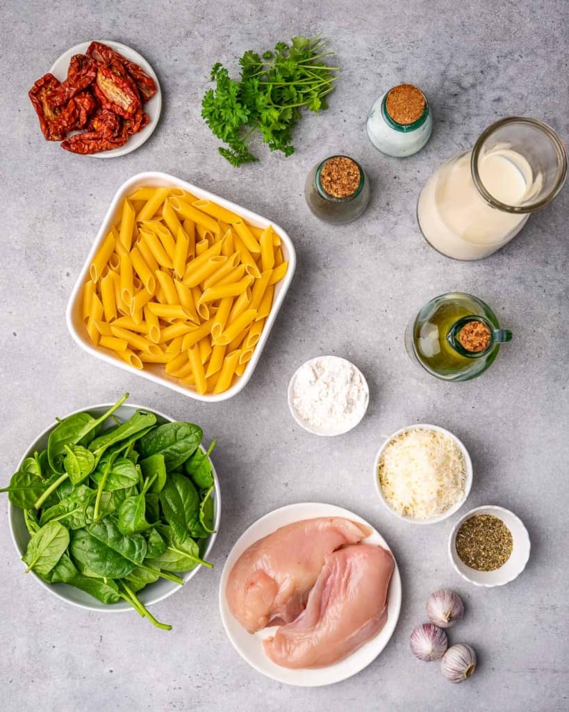 Spinach, tomatoes, pasta, chicken breasts, Parmesan, olive oil, Italian seasoning, salt, pepper, garlic, flour, milk, and parsley