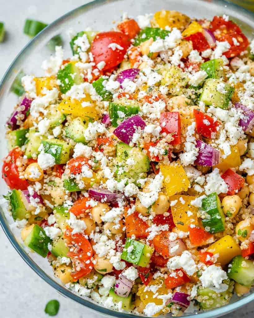 close up chickpea  veggie and quinoa salad topped with feta cheese