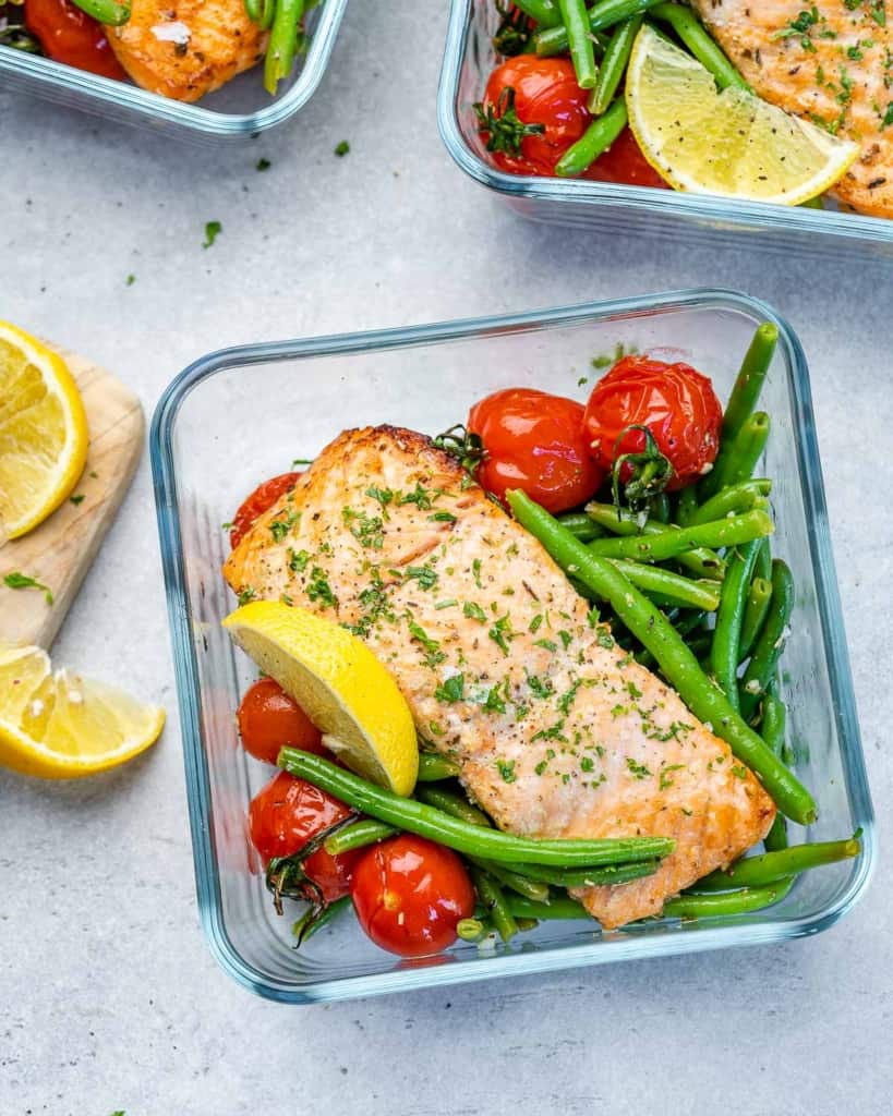 One meal prep bowl filled with salmon, tomatoes, and green beans