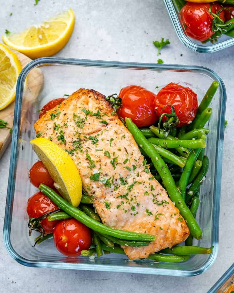 Salmon sitting on top of tomatoes and green beans