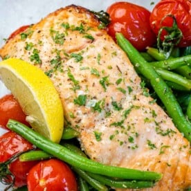 One salmon fillet with green beans, lemon wedge, and tomatoes