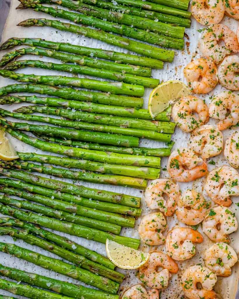 top view baked shrimp and asparagus on a sheet pan