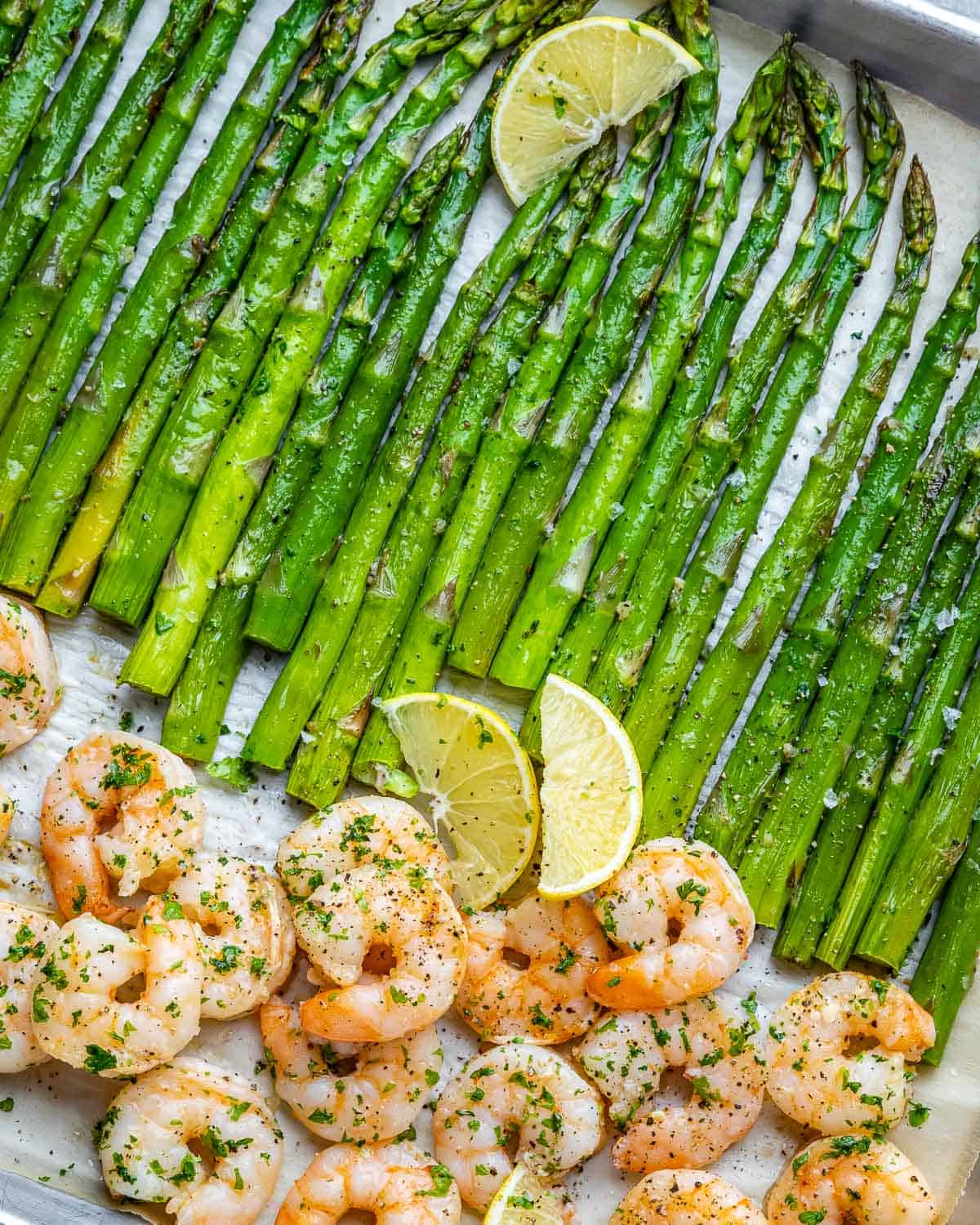 Top view of angled sheet pan with asparagus and shrimp.