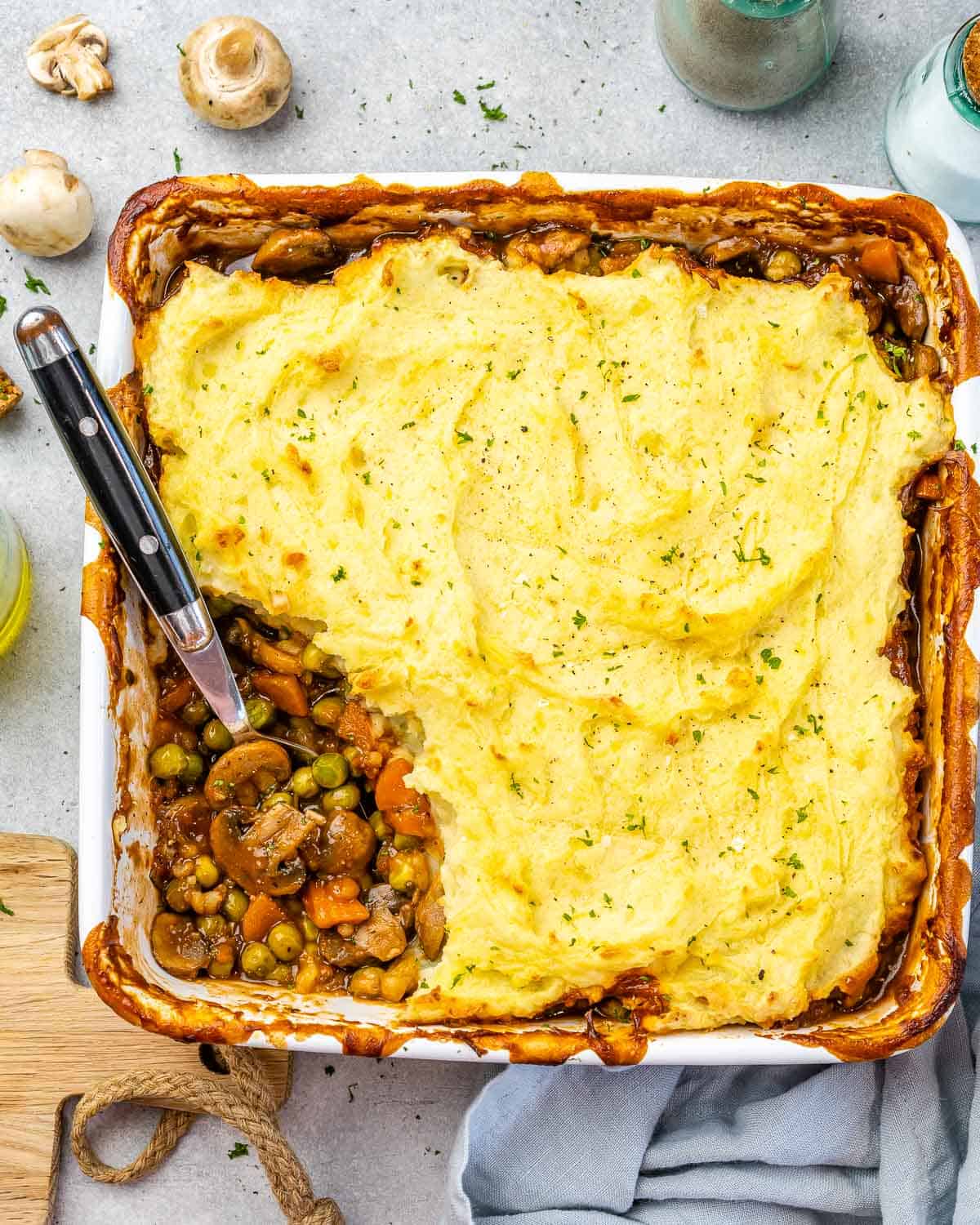 Top view vegetarian shepherds pie with spoon scooping some.