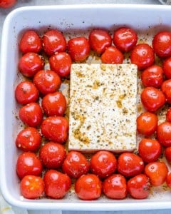 tomatoes and feta in a dish before baking