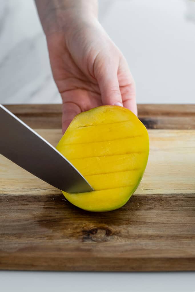 knife slicing flesh of mango