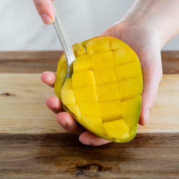 spoon scooping mango flesh from mango