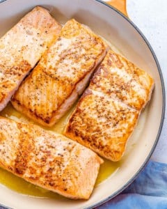 seared salmon filets in a pan.