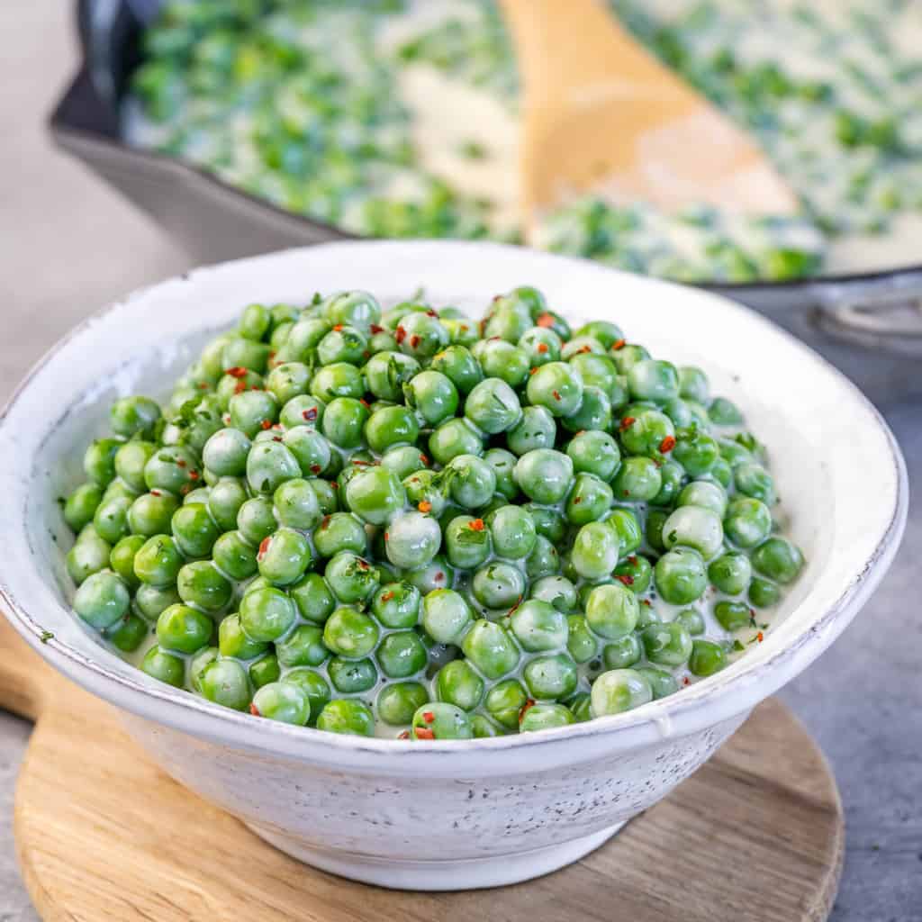 side view of peas in a white bowl
