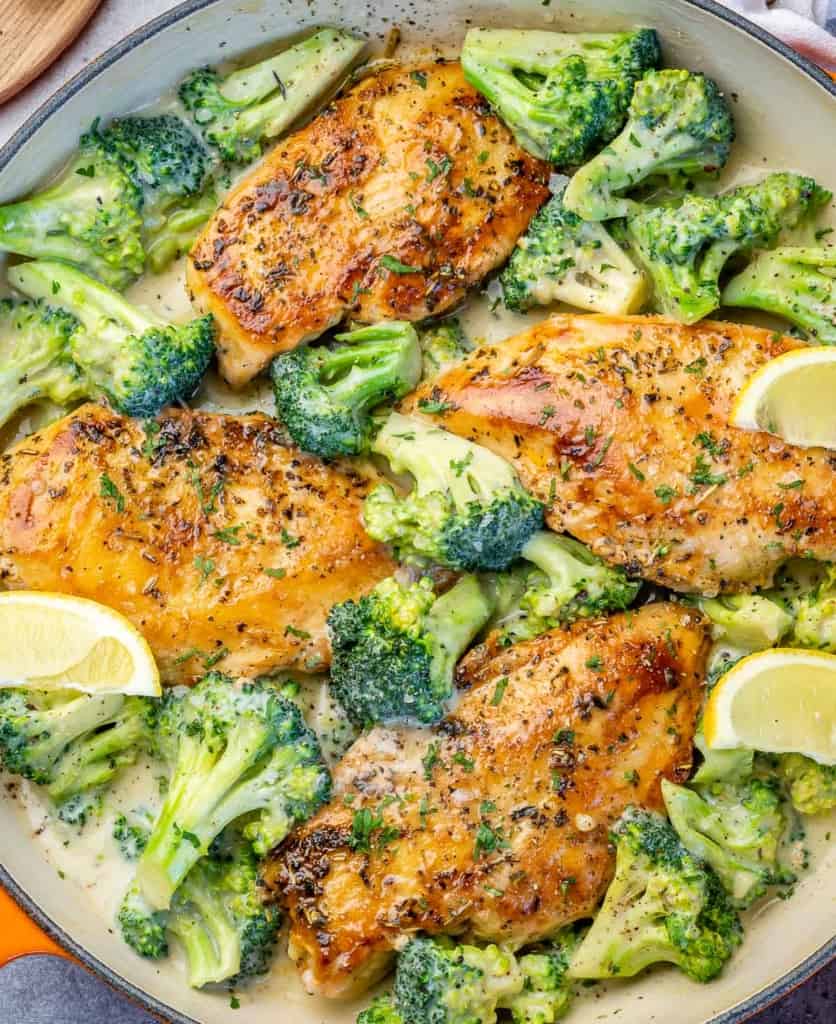 close up chicken and broccoli skillet with lemon wedges 