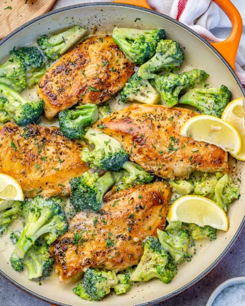 top view chicken and broccoli in an orange skillet