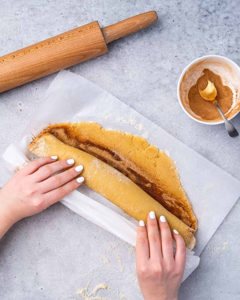 Keto cinnamon roll dough being rolled