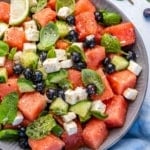 Top view of watermelon feta salad in bowl with lime wedges