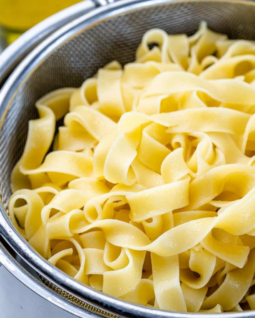 close up cooked fettuccine pasta in colander