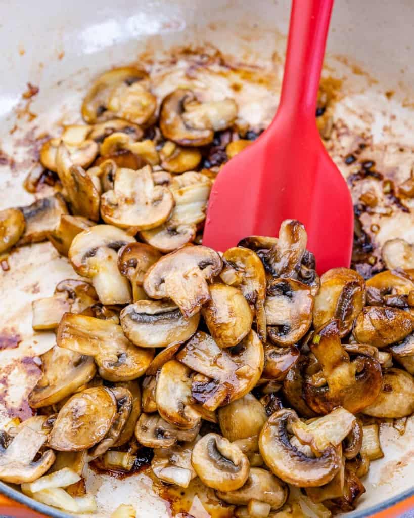 Mushrooms being stirred in pan with spatula