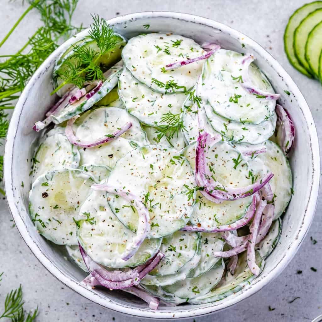 top view creamy cucumber salad in a white bowl