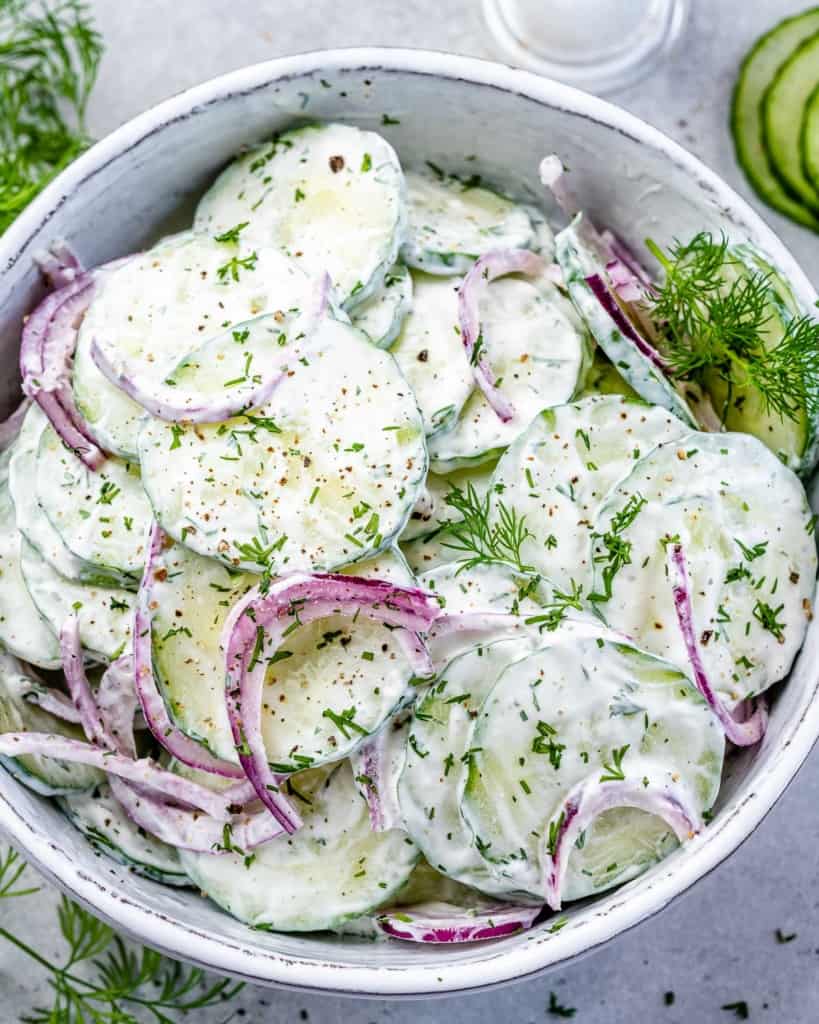creamy cucumber salad in a white bowl