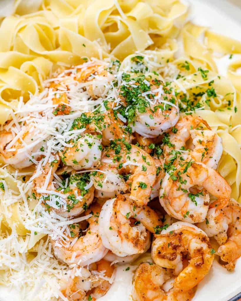 shrimp and sauce added over fettuccine pasta 