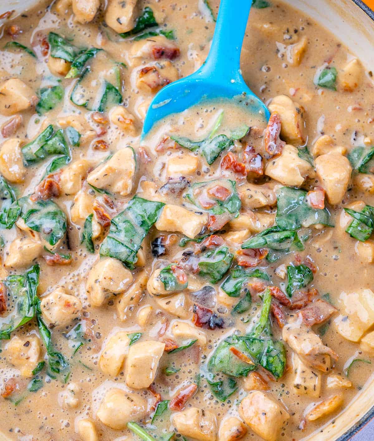 creamy chicken sauce with spinach in a skillet.