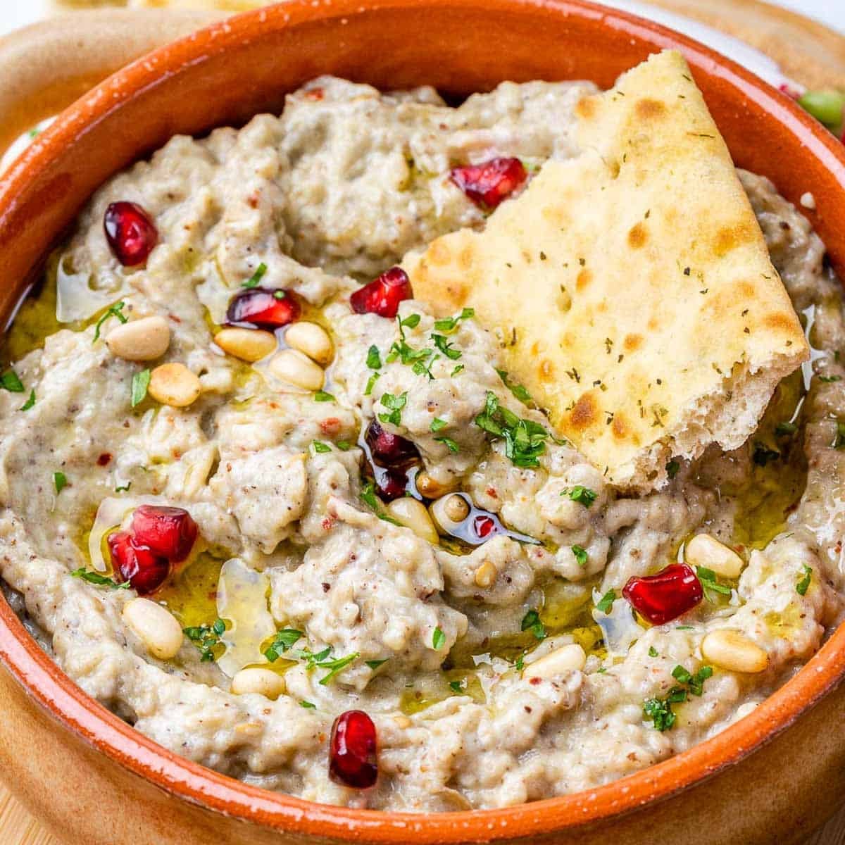 a pit in a bowl filled with roasted baba ganoush dip.