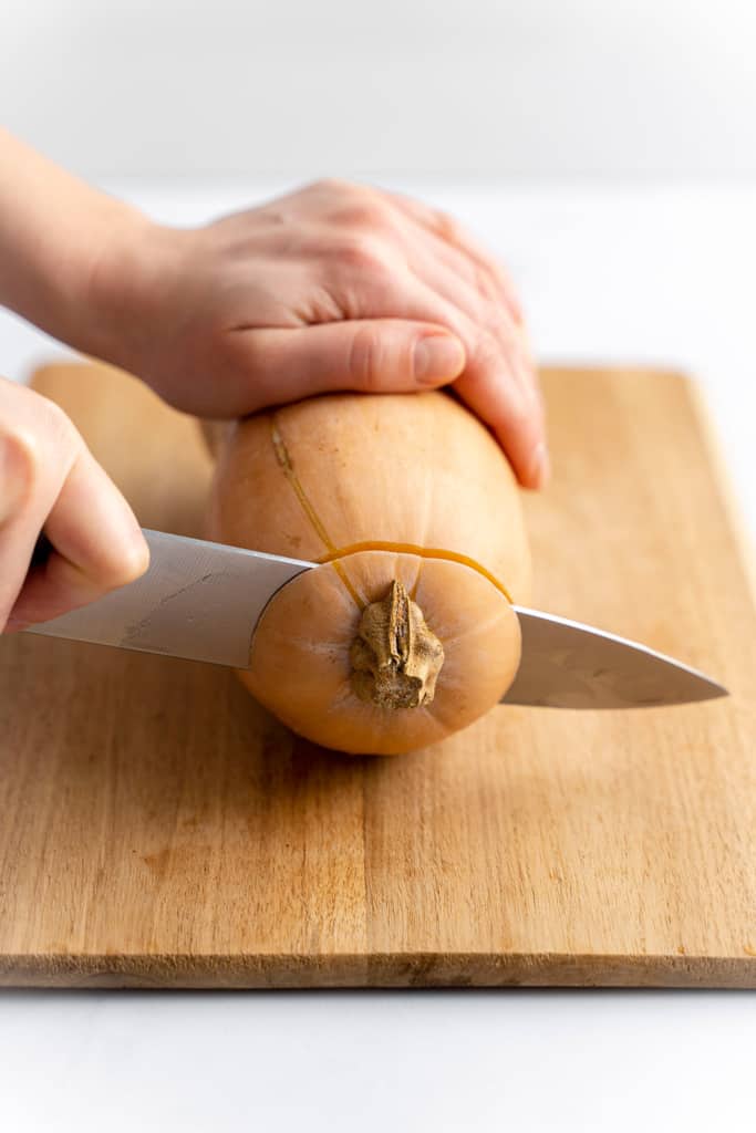 Cutting the top off a butternut squash.