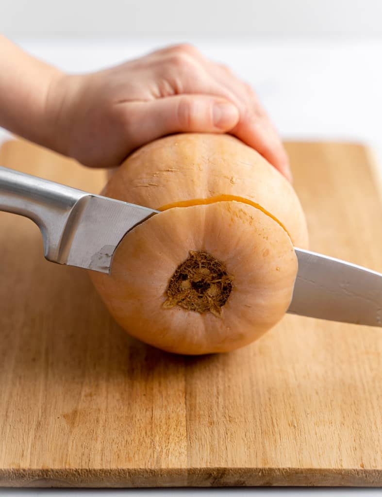 side shot of how knife slicing the bottom end of the butternut squash