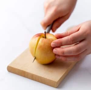 side shot of hand slicing apple with knife