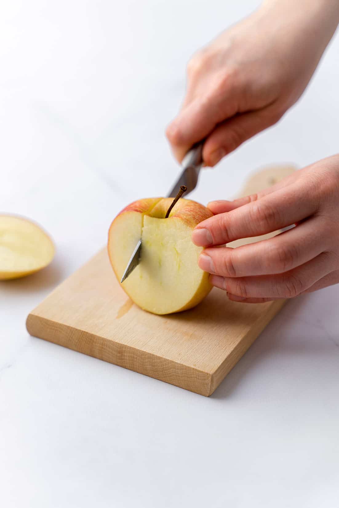 cutting off four slices of apple away from core 