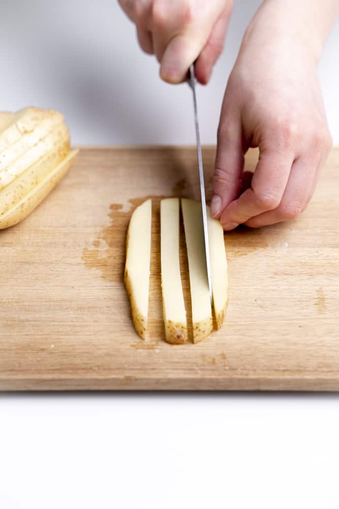 slicing a potato into strips
