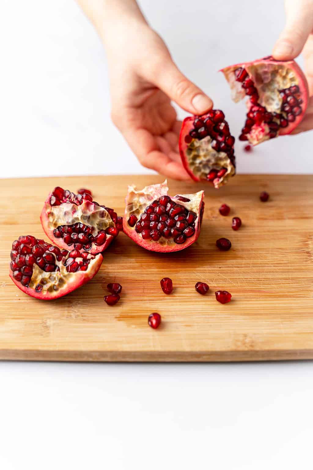 deseeding and splitting the pomegranate on cutting board