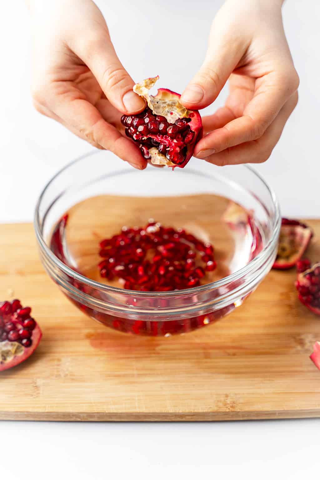 deseeding the pomegranate over one bowl of water 