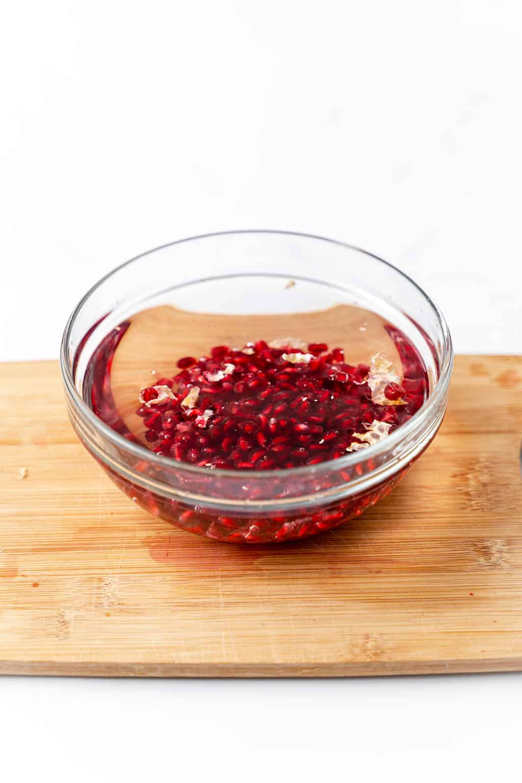 one bowl of pomegranate seeds in water 