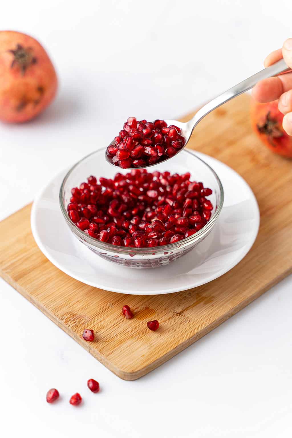 one bowl filled with fresh pomegranate arils in a spoon 