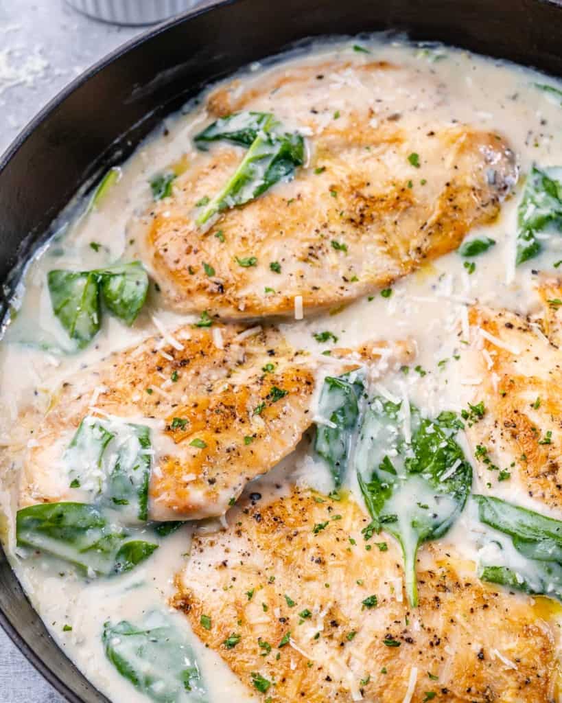 top view of chicken in skillet with creamy sauce