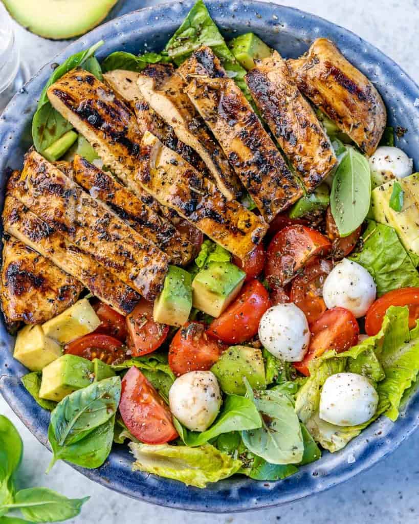 top view caprese salad topped with grilled chicken