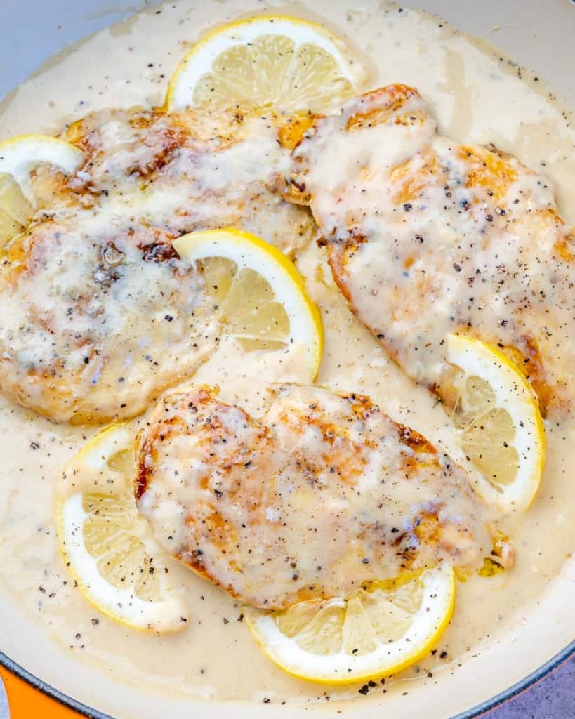 top view of chicken breast in a creamy lemon sauce with lemon slices