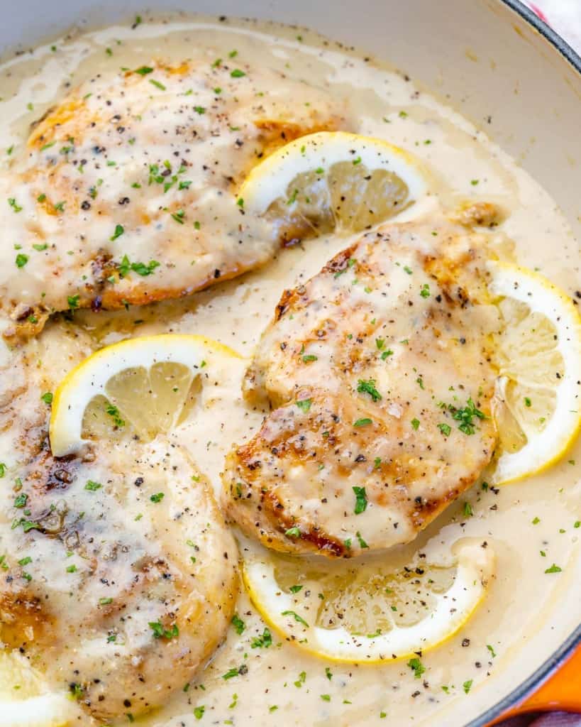 side shot of cooked chicken breast in a creamy lemony sauce