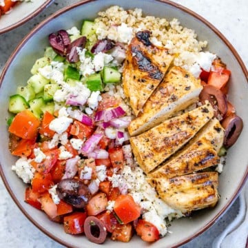 top view grilled chicken with greek inspired salad and quinoa in a bowl