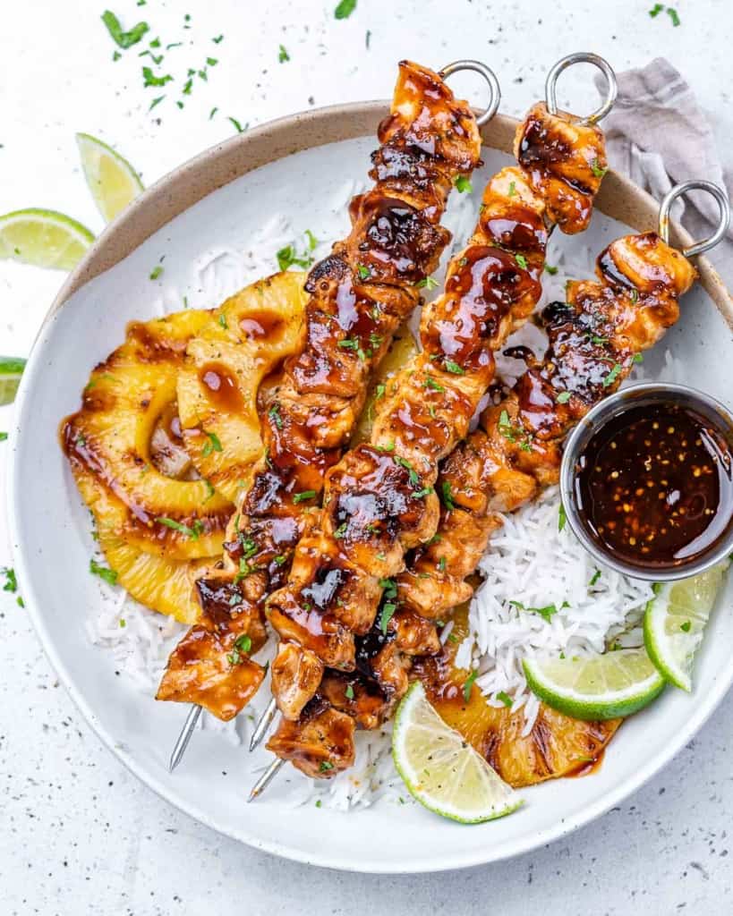 Three skewers with chicken on rice