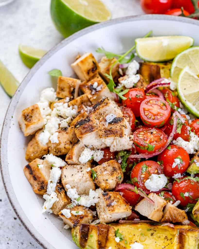 close view of chicken avocado salad with limes and onion 