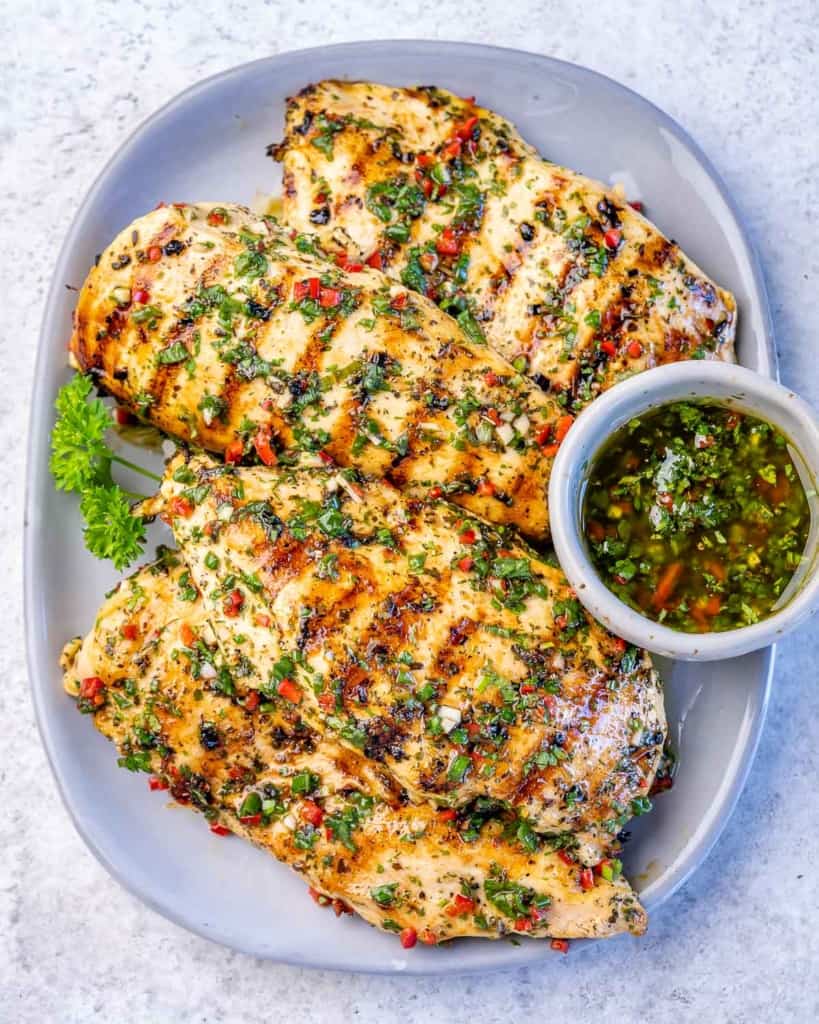 grilled chicken breast with chimichurri sauce on the side  