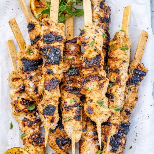 top view grilled chicken skewers stacked on each other on a plate