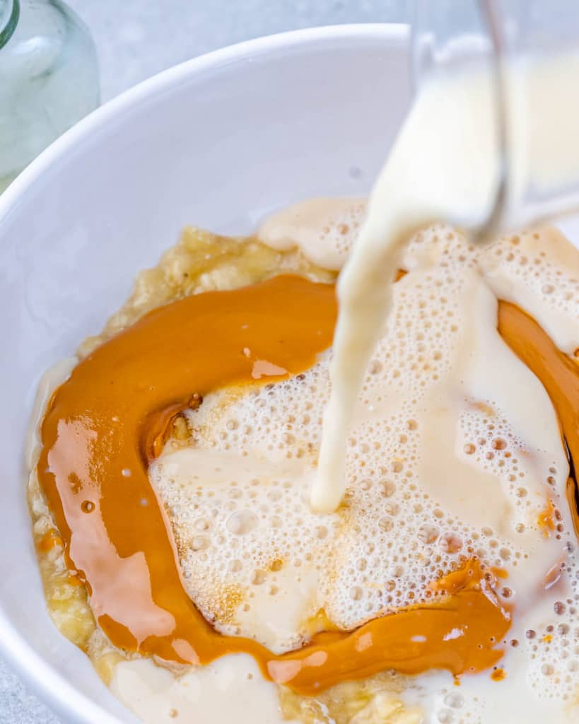 maple syrup and milk in a bowl with peanut butter and banana