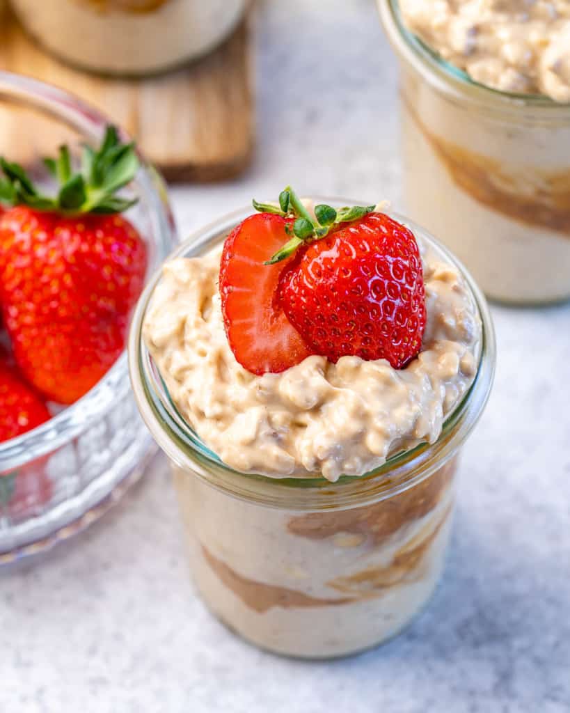 top view of peanut butter overnight oats in a jar and topped with fresh strawberries 